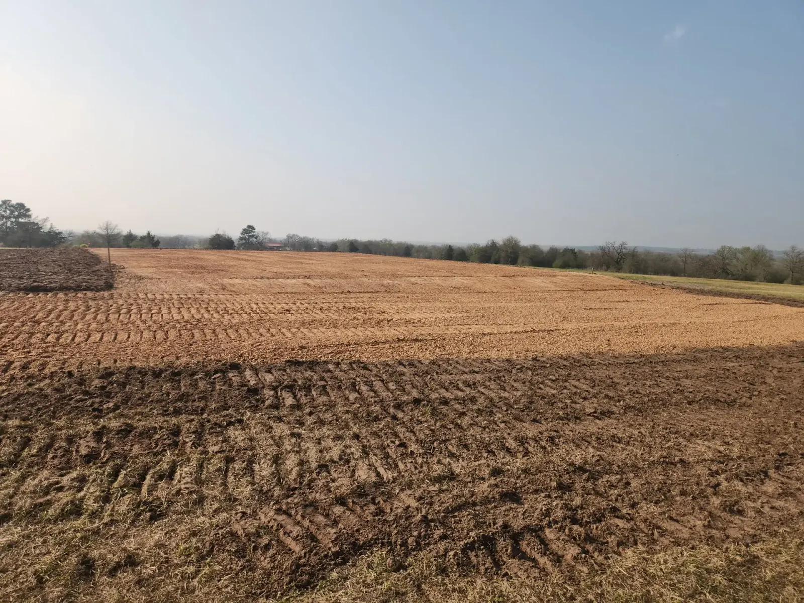 Large freshly graded field with dozer track marks