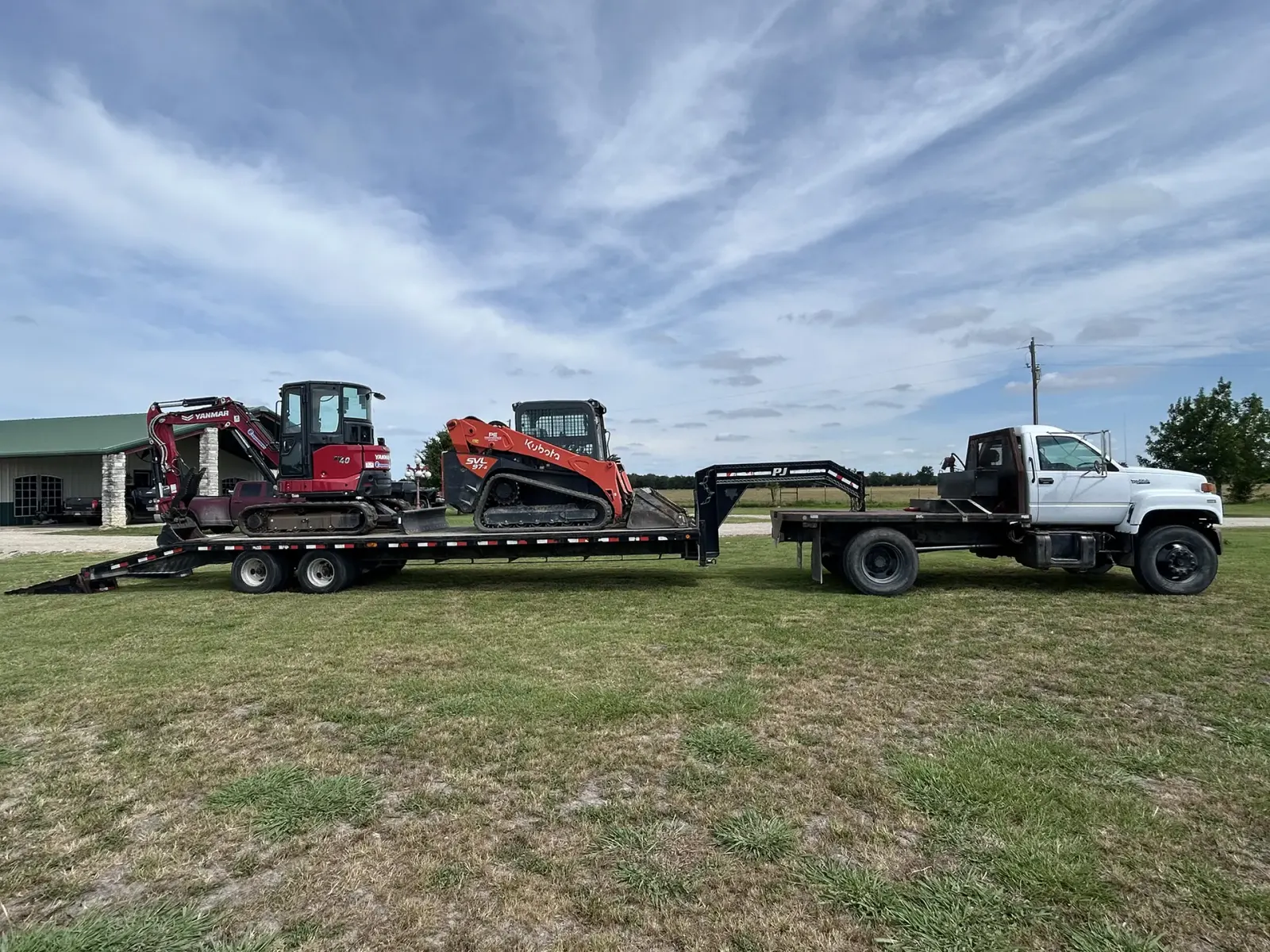 Excavator and track loader loaded on a gooseneck trailer
