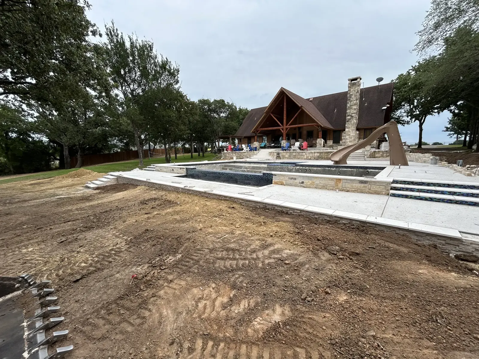 Fresh grading around a newly built stone and timber home