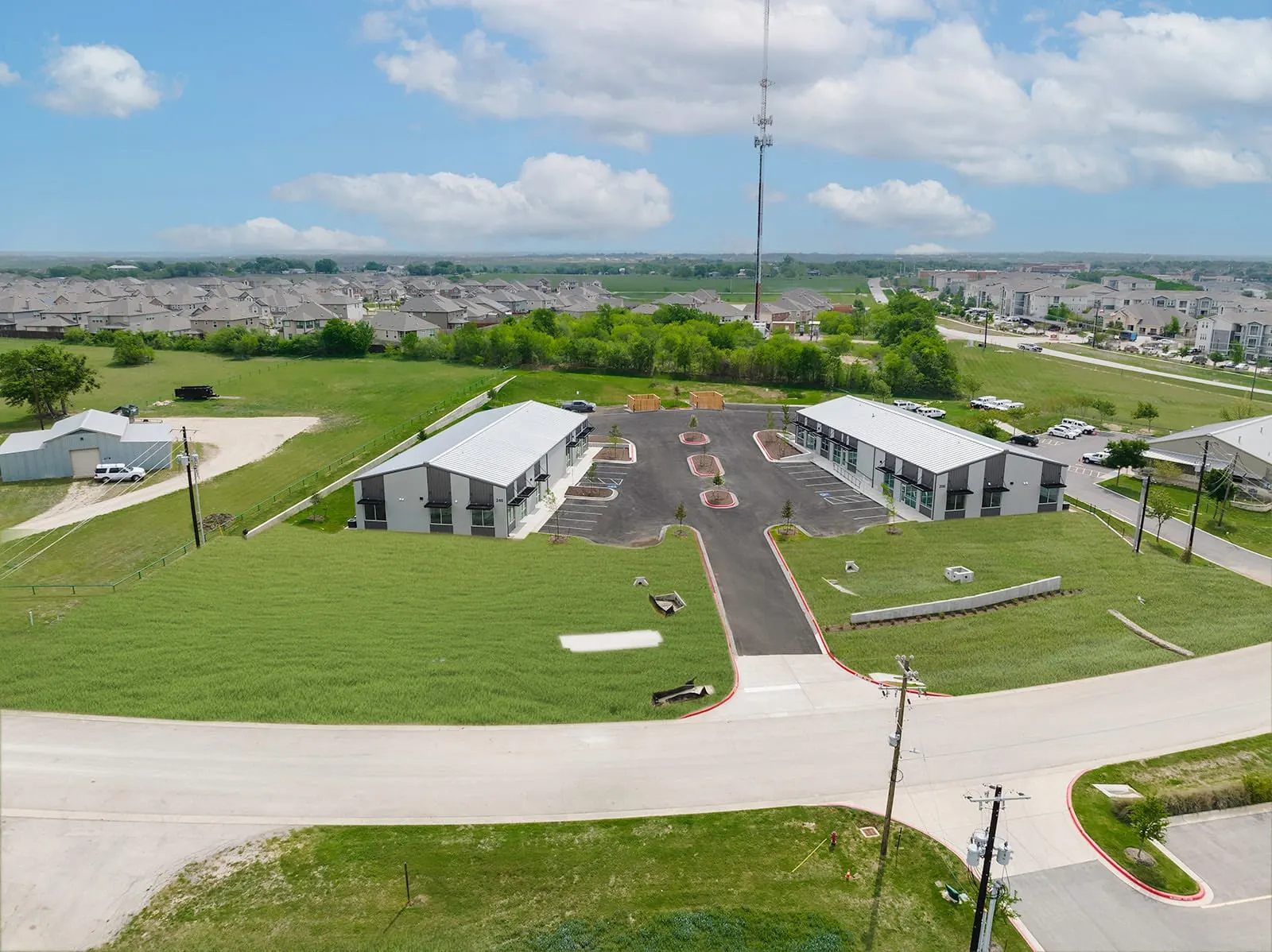 Aerial view of a completed business park with new paving and landscaping in Kyle, TX