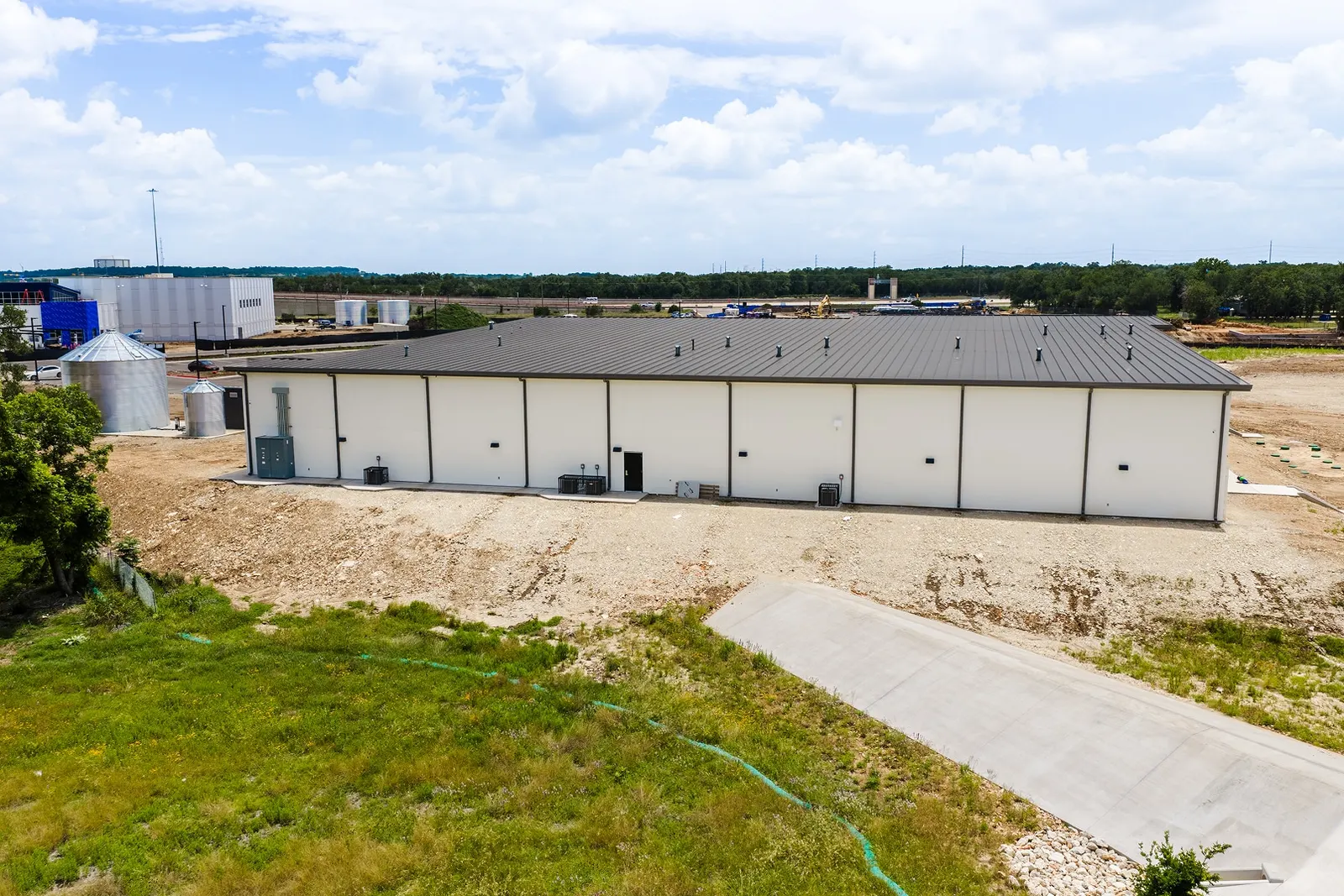 New metal building with a concrete drive ramp on a graded site