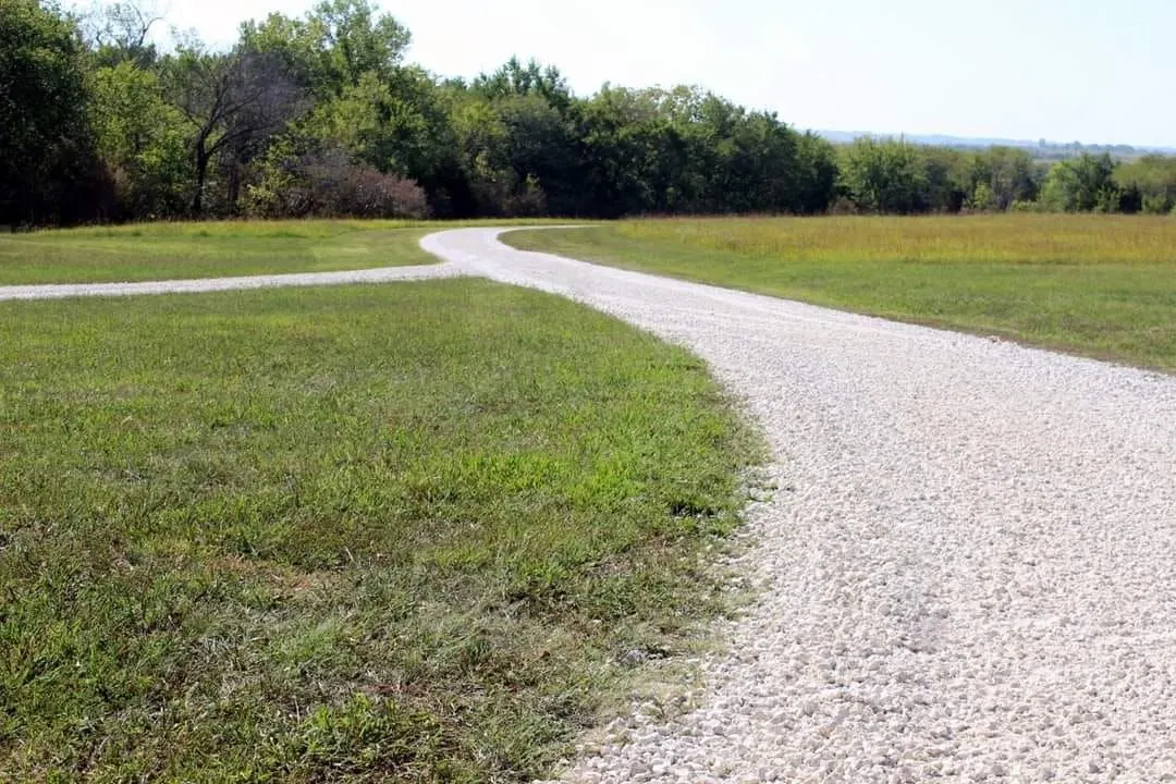Curving gravel driveway built through an open pasture