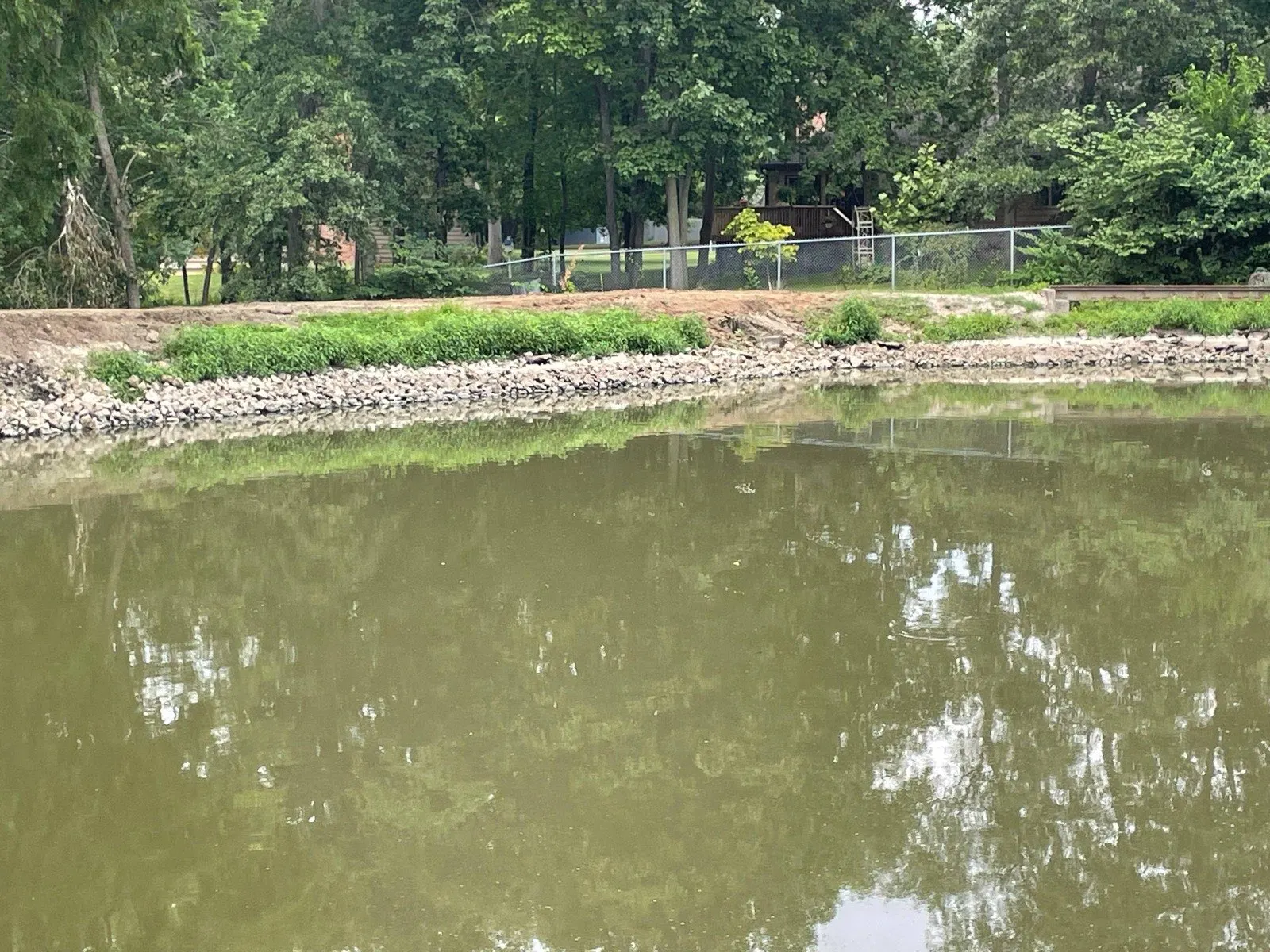 Rebuilt pond dam with riprap along the bank after repair in Decatur, IL