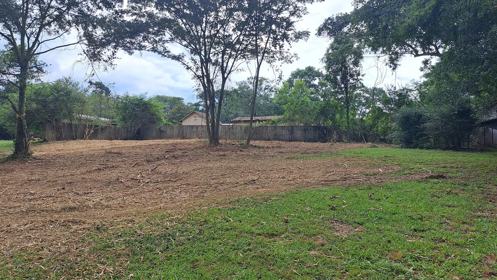 Overgrown backyard cleared to open ground by Meeks Land Management near Fort Payne, AL