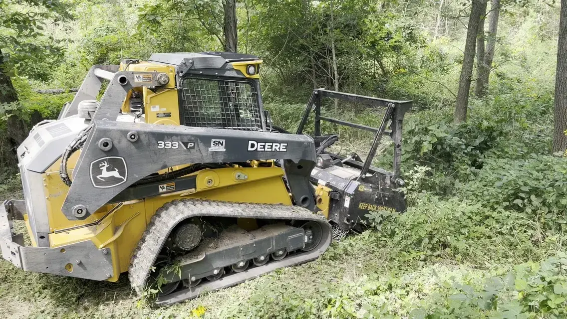 John Deere 333 compact track loader with a forestry mulching head working into brush in mid-Missouri