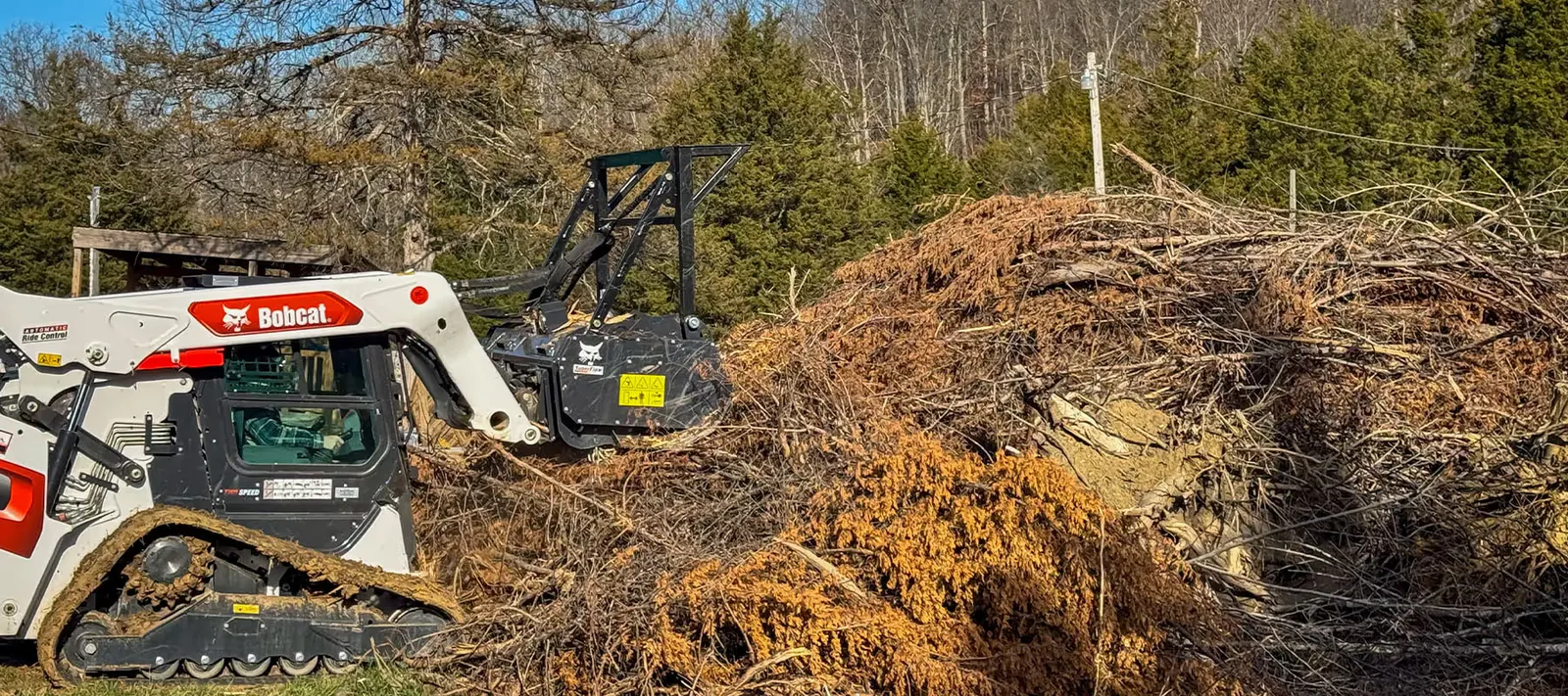Bobcat forestry mulcher working a large brush pile