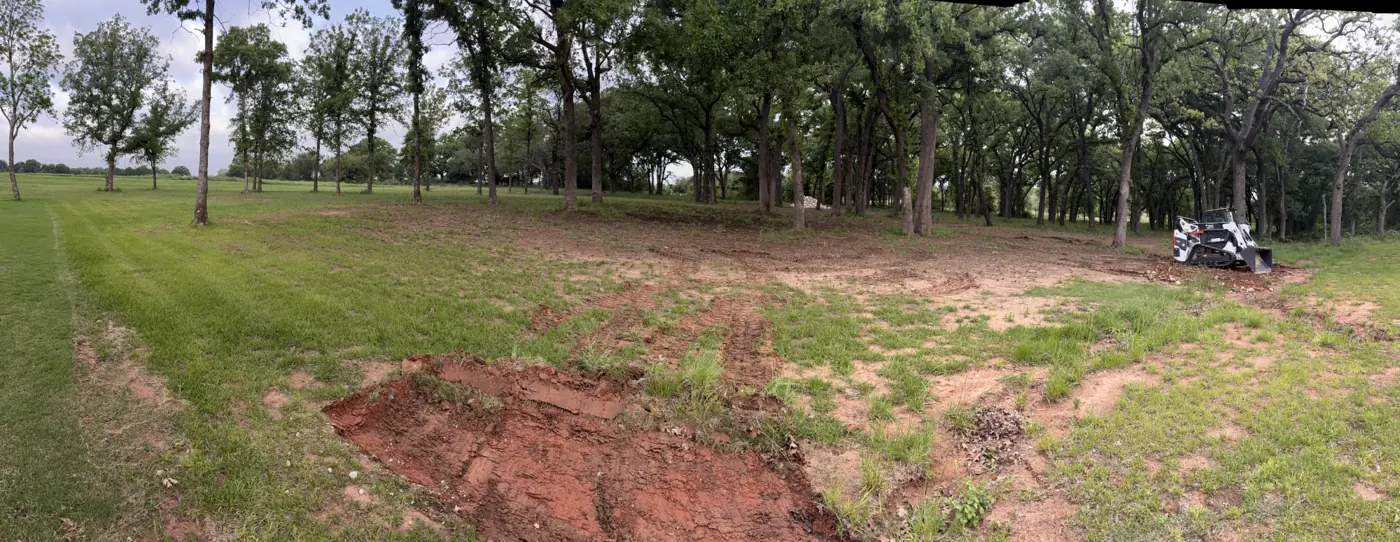 Wide view of a cleared lot with mature trees kept in Granbury, TX