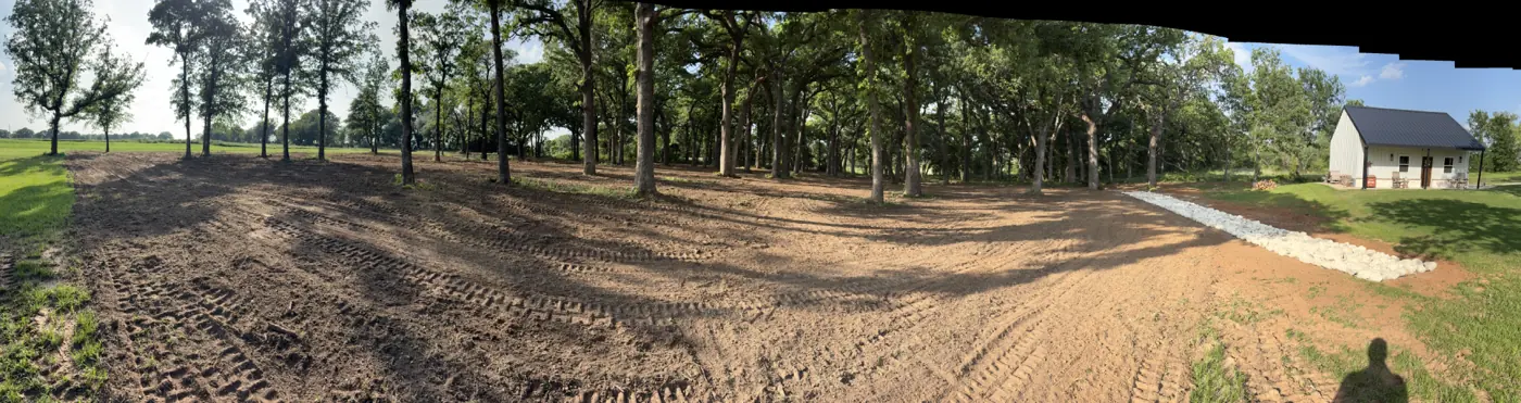 Dirt access drive cut through a cleared wooded lot in Central Texas