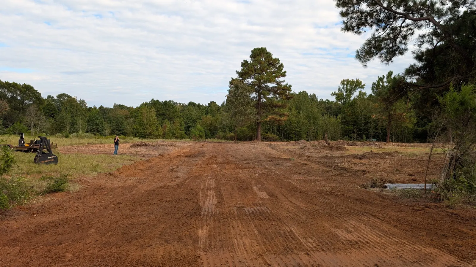 Freshly graded red clay site cleared out of East Texas woods