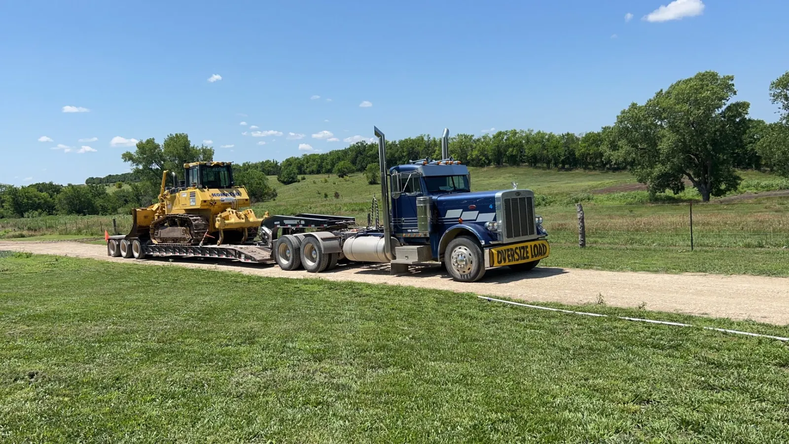 Dozer loaded on a lowboy trailer behind a semi truck