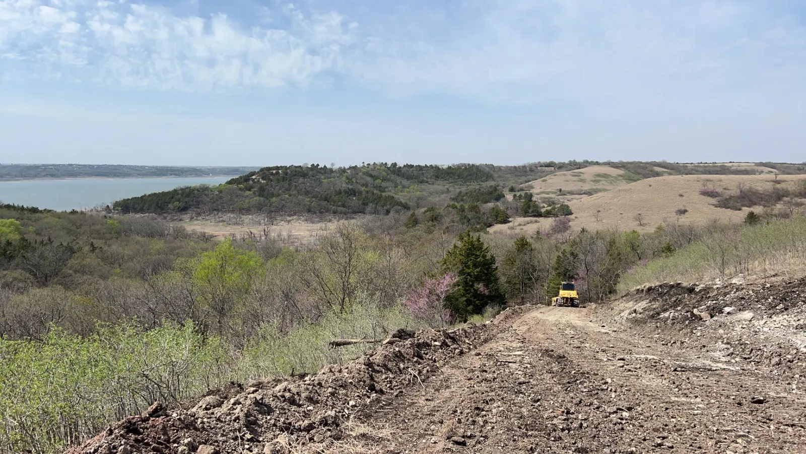 Cleared hilltop access with a dozer and a lake in the distance
