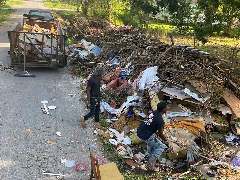 Crew loading a large debris pile onto a trailer