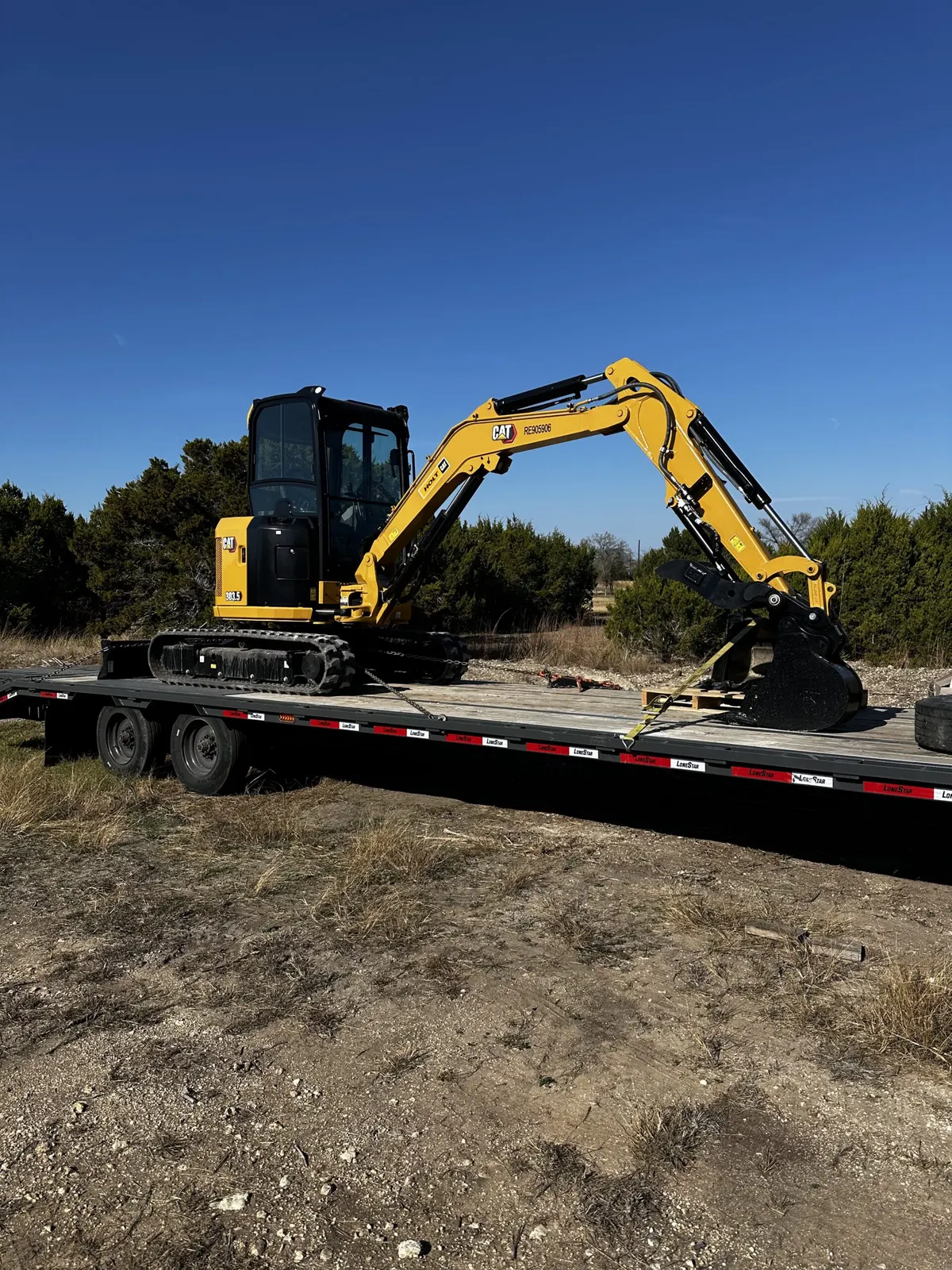 CAT mini excavator loaded on a trailer at a ranch property