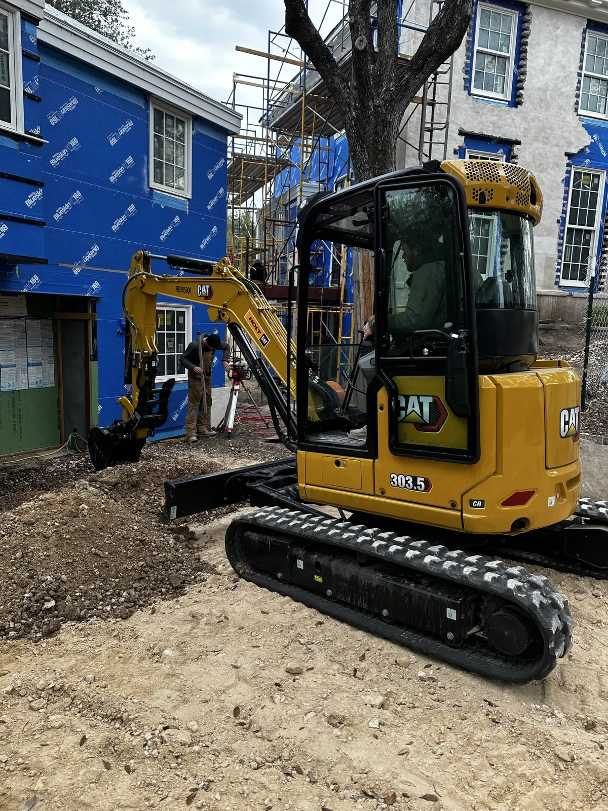 CAT mini excavator working next to a house under construction