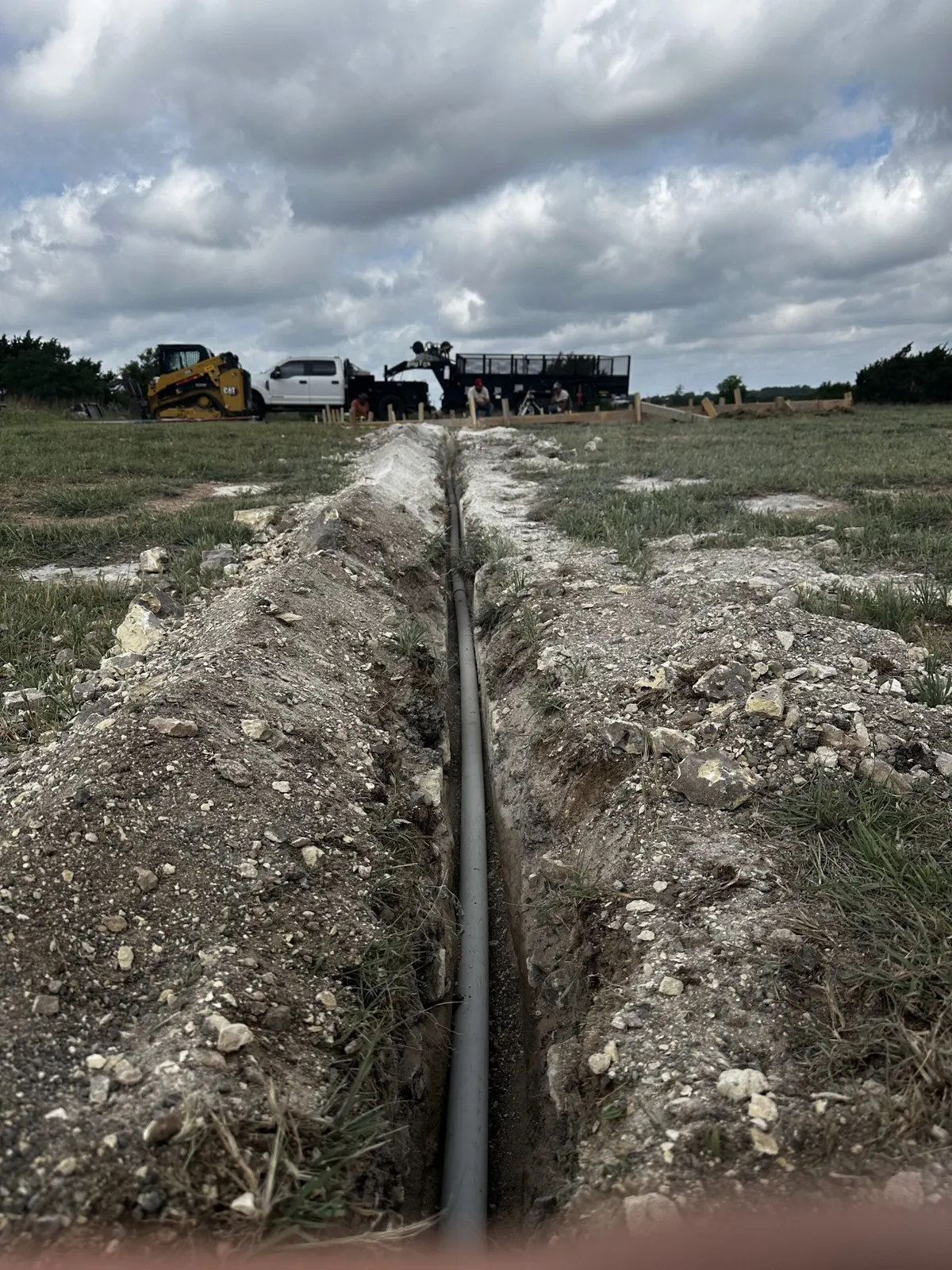 Open utility trench with pipe laid across a Central Texas property